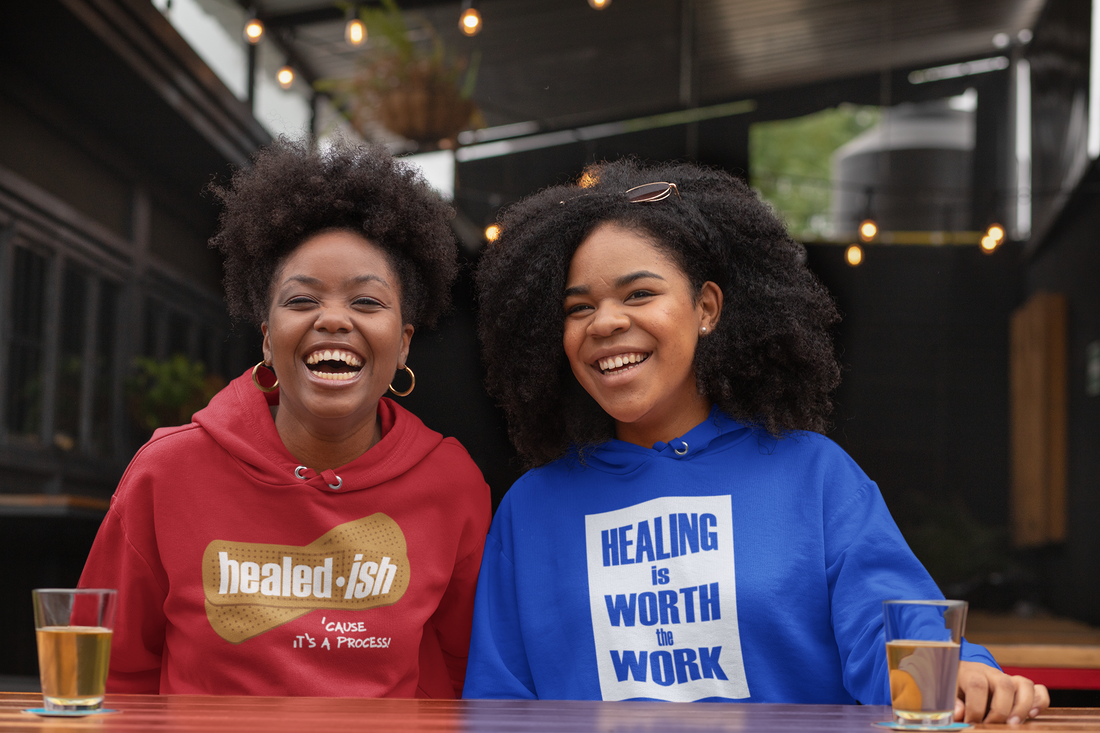 Two friends wearing healed-ish positive message hoodies